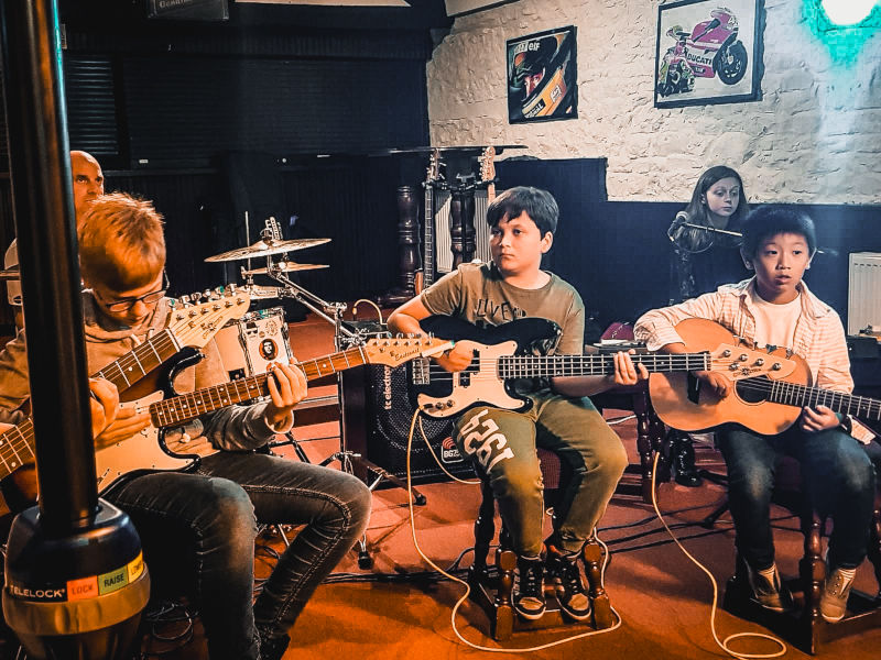 Group of kids learning guitar